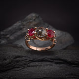 Anillo de compromiso con diamante natural "sal y pimienta" central de 1.20ct corte brillante, 2 rubíes naturales y 4 diamantes negros naturales elaborado en oro rosa de 14k
