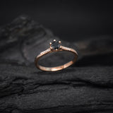 Anillo de compromiso con diamante negro natural central de .40ct corte brillante y 12 cristales laterales elaborado en oro rosa de 14k