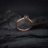 Anillo de compromiso con diamante negro natural central de .40ct corte brillante y 12 cristales laterales elaborado en oro rosa de 14k