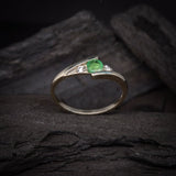 Anillo de compromiso con esmeralda natural de .20ct corte brillante y 2 cristales laterales elaborado en plata .930