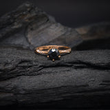 Anillo de compromiso con diamante negro natural central de .70ct corte brillante y 12 cristales laterales elaborado en oro rosa de 14k