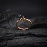 Anillo de compromiso con diamante negro natural central de .70ct corte brillante y 12 diamantes naturales laterales elaborado en oro rosa de 14k