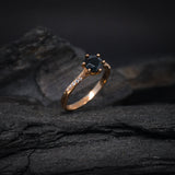 Anillo de compromiso con diamante negro natural central de .70ct corte brillante y 12 cristales laterales elaborado en oro rosa de 14k