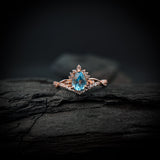 Anillo de compromiso con topacio natural de .80ct corte gota y diamantes naturales laterales elaborado en oro rosa de 14k