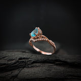 Anillo de compromiso con topacio natural de .80ct corte gota y diamantes naturales laterales elaborado en oro rosa de 14k