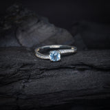 Anillo de compromiso con topacio natural de .50ct corte brillante y cristales laterales elaborado en plata .925