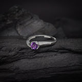 Anillo de compromiso con amatista natural de .50ct corte brillante y cristales laterales elaborado en plata .925