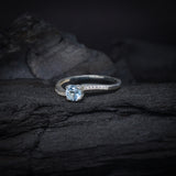 Anillo de compromiso con topacio natural de .50ct corte brillante y cristales laterales elaborado en plata .925