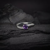 Anillo de compromiso con amatista natural de .50ct corte brillante y cristales laterales elaborado en plata .925