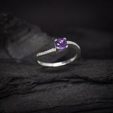 Anillo de compromiso con amatista natural de .50ct corte brillante y cristales laterales elaborado en plata .925