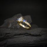 Anillo de compromiso con diamante natural de .50ct corte gota, 12 moissanitas y 2 zafiros naturales corte princesa elaborado en oro amarillo de 14k