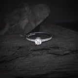 Anillo de compromiso con diamante natural central de .50ct corte brillante y 16 diamantes naturales laterales elaborado en oro blanco de 14k