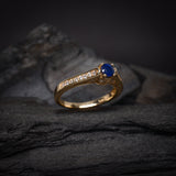 Anillo de compromiso con zafiro natural de .50ct corte brillante y 24 cristales laterales elaborado en oro amarillo de 14k