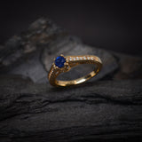 Anillo de compromiso con zafiro natural de .50ct corte brillante y 24 cristales laterales elaborado en oro amarillo de 14k