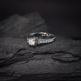 Anillo de compromiso con diamante natural central de .40ct corte brillante con certificación GIA, 2 esmeraldas y 12 diamantes naturales laterales elaborado en oro blanco de 14k