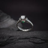 Anillo de compromiso con diamante natural central de .40ct corte brillante con certificación GIA, 2 esmeraldas y 12 diamantes naturales laterales elaborado en oro blanco de 14k