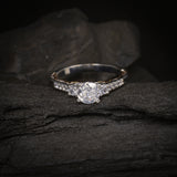 Anillo de compromiso con diamante natural central de .60ct corte brillante con certificado GIA y 12 cristales laterales elaborado en oro blanco y rosa de 14k