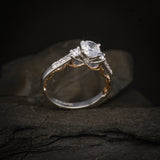 Anillo de compromiso con diamante natural central de .60ct corte brillante con certificado GIA y 12 cristales laterales elaborado en oro blanco y rosa de 14k