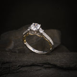 Anillo de compromiso con diamante natural central de .60ct corte brillante con certificado GIA y 12 cristales laterales elaborado en oro blanco y amarillo de 14k