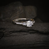 Anillo de compromiso con diamante natural central de .60ct corte brillante con certificado GIA y 12 cristales laterales elaborado en oro blanco y amarillo de 14k