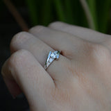 Anillo de compromiso con moissanita de .20ct corte brillante y 2 cristales laterales elaborado en plata .930