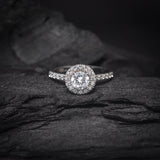 Anillo de compromiso con diamante natural central de .50ct corte brillante con certificación GIA y cristales laterales elaborado en oro blanco de 14k