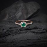 Anillo de compromiso con esmeralda natural de .50ct corte brillante y 32 diamantes naturales laterales elaborado en oro rosa de 14k