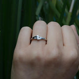 Anillo de compromiso con moissanita de .20ct corte brillante y 2 cristales laterales elaborado en plata .930