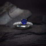 Anillo de compromiso con zafiro natural de .50ct corte brillante y 48 diamantes laterales elaborado en oro blanco de 14k