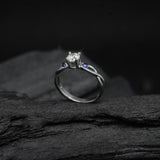Anillo de compromiso con diamante natural de .20ct corte brillante y 2 zafiros naturales laterales elaborado en oro blanco de 14k
