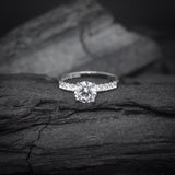 Anillo de compromiso con diamante natural central de .60ct corte brillante con certificación GIA y 20 diamantes naturales laterales elaborado en oro blanco de 14k