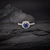 Anillo de compromiso con zafiro natural de 1.0ct corte brillante y 27 cristales elaborado en oro blanco de 14k