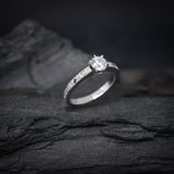 Anillo de compromiso con diamante natural central de .50ct corte brillante con certificación GIA, 2 zafiros naturales y 18 diamantes naturales laterales en oro blanco de 14k