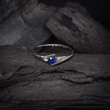 Anillo de compromiso con zafiro natural de .20ct corte brillante y 2 cristales laterales elaborado en plata .930