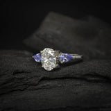 Anillo de compromiso con diamante de laboratorio de 1.0ct corte oval con certificado IGI y 2 tanzanitas naturales laterales elaborado en oro blanco de 14k