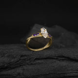 Anillo de compromiso con diamante natural de .70ct corte marquise con certificación GIA y 2 zafiros morados naturales laterales elaborado en oro amarillo de 14k