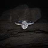 Anillo de compromiso con moissanita de 1.0ct corte oval con certificado GRA y 14 moissanitas laterales elaborado en oro blanco de 14k