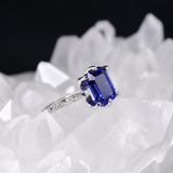Anillo de compromiso con zafiro natural de 1.0ct corte esmeralda y 2 moissanitas laterales elaborado en oro blanco de 14k