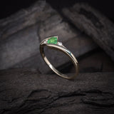 Anillo de compromiso con esmeralda natural de .20ct corte brillante y 2 cristales elaborado en oro blanco de 10k