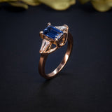 Anillo de compromiso con zafiro natural de 1.30ct corte esmeralda y 2 diamantes naturales elaborado en oro rosa de 14k