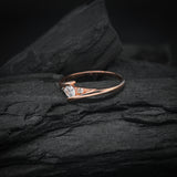 Anillo de compromiso con moissanita de .20ct corte brillante y 2 cristales laterales elaborado en oro rosa de 10k