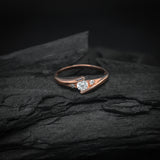 Anillo de compromiso con moissanita de .20ct corte brillante y 2 cristales laterales elaborado en oro rosa de 10k