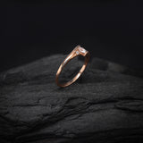 Anillo de compromiso con moissanita de .20ct corte brillante y 2 cristales laterales elaborado en oro rosa de 10k