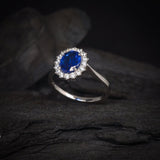 Anillo de compromiso con zafiro natural de 1.5ct corte oval y cristales laterales elaborado en plata .925