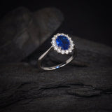 Anillo de compromiso con zafiro natural de 1.5ct corte oval y cristales laterales elaborado en plata .925