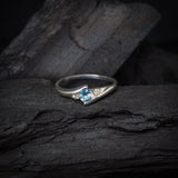 Anillo de compromiso con topacio natural de .20ct corte brillante y 2 cristales elaborado en oro blanco de 10k