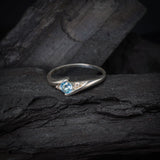 Anillo de compromiso con topacio natural de .20ct corte brillante y 2 cristales elaborado en oro blanco de 10k