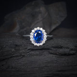 Anillo de compromiso con zafiro natural de 1.5ct corte oval y cristales laterales elaborado en plata .925
