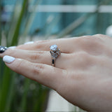 Anillo de compromiso con moissanita de 1.0ct corte brillante con certificado GRA y 18 cristales laterales realizado en oro blanco de 14k