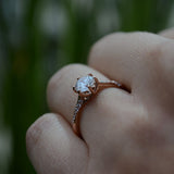 Anillo de compromiso con moissanita de 1.0ct corte brillante con certificado GRA y 12 diamantes naturales laterales realizado en oro rosa de 14k